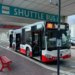 Autobus wahadłowy z lotniska do centrum miasta, z numerem 16, gotowy do odjazdu.