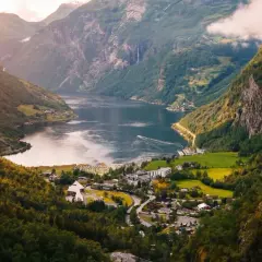 Widok na fiord w Norwegii, z malowniczą wioską u podnóża gór. Idealne miejsce, by zobaczyć cuda natury.