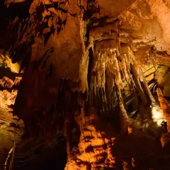 Wnętrze jaskini z naciekami, stalaktytami i stalagmitami, oświetlone ciepłym światłem. Możliwe, że to najdłuższa jaskinia na świecie.