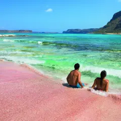 Para na różowej plaży Elafonisi na Krecie. Warto zobaczyć to miejsce, gdzie turkusowe morze spotyka się z piaskiem.
