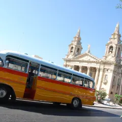 Malta: zabytkowy autobus i dorożka na tle kościoła. Idealne na wycieczkę, kup malta bilety autobusowe!