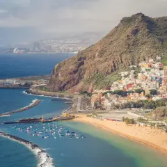 Kolorowe domki na zboczu góry nad plażą z łódkami. Czy to Teneryfa czy Fuerteventura?