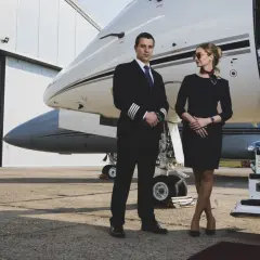 Pilot i stewardesa przy prywatnym odrzutowcu. Czy to początek podróży czarterem?