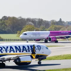 Dwa samoloty na płycie lotniska: jeden z napisem Ryanair, drugi z logo Wizzair. Którego wybierasz na wakacje?