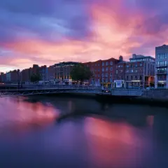 Zachód słońca nad rzeką Liffey w Dublinie. Warto zobaczyć te malownicze budynki i most w różowych barwach nieba.