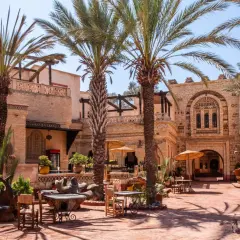 Agadir co zobaczyc: urokliwy dziedziniec z palmami, tradycyjną architekturą i miejscami do siedzenia. Idealne miejsce na relaks.