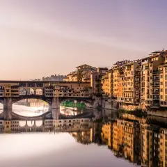 Mostra Ponte Vecchio we Florencji, idealne miejsce do zobaczenia. Złote światło odbija się w rzece Arno.