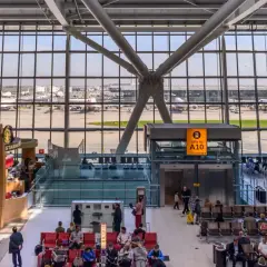 Wnętrze największego lotniska w Londynie, z widokiem na samoloty British Airways i pasażerów oczekujących na loty.