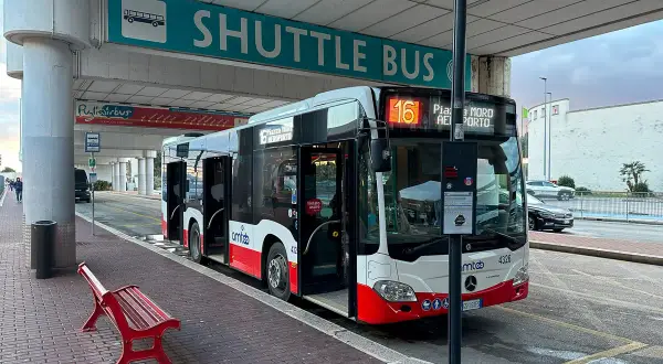 Autobus wahadłowy z lotniska do centrum miasta, z numerem 16, gotowy do odjazdu.