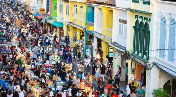 Tłoczny nocny targ w Phuket, pełen kolorowych budynków i ludzi. Idealne miejsce, by poczuć atmosferę i zastanowić się, phuket kiedy jechać.