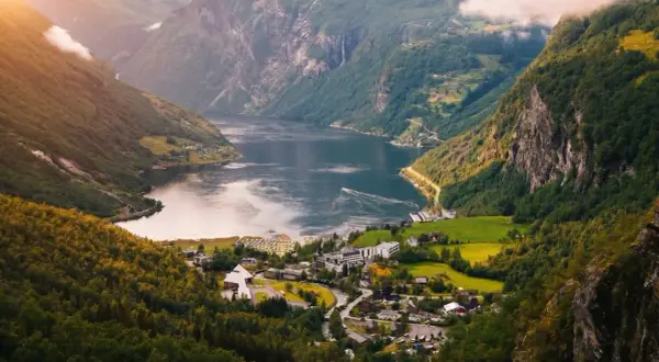 Widok na fiord w Norwegii, z malowniczą wioską u podnóża gór. Idealne miejsce, by zobaczyć cuda natury.