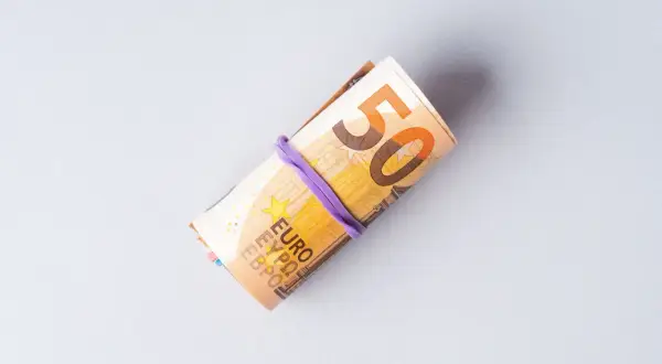Zrolowane banknoty euro, widoczna cyfra 50. Symbolizują ceny w Niemczech i koszty życia.