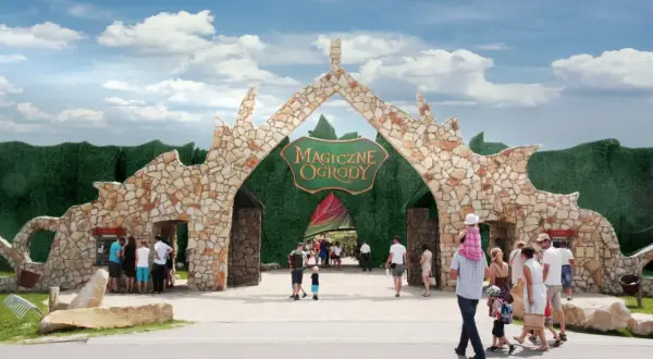 Kamienna brama "Magiczne Ogrody" zaprasza na niezapomniane atrakcje dla młodzieży. Rodziny wchodzą do bajkowego świata.