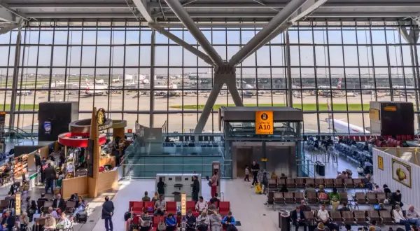 Wnętrze największego lotniska w Londynie, z widokiem na samoloty British Airways i pasażerów oczekujących na loty.