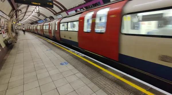 Metro londyn bilet 3 dniowy. Pociąg z czerwonymi i beżowymi elementami mija peron. Na tablicy informacja o odjeździe do Edgware.