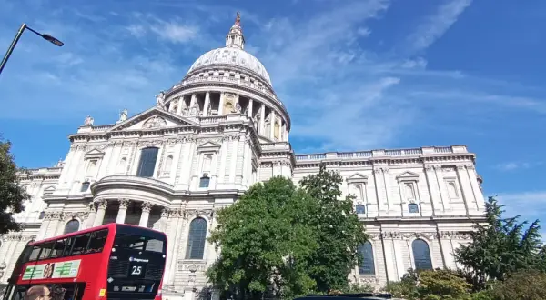 Piękny dzień na weekend w Londynie! Katedra św. Pawła i czerwony autobus piętrowy pod błękitnym niebem.