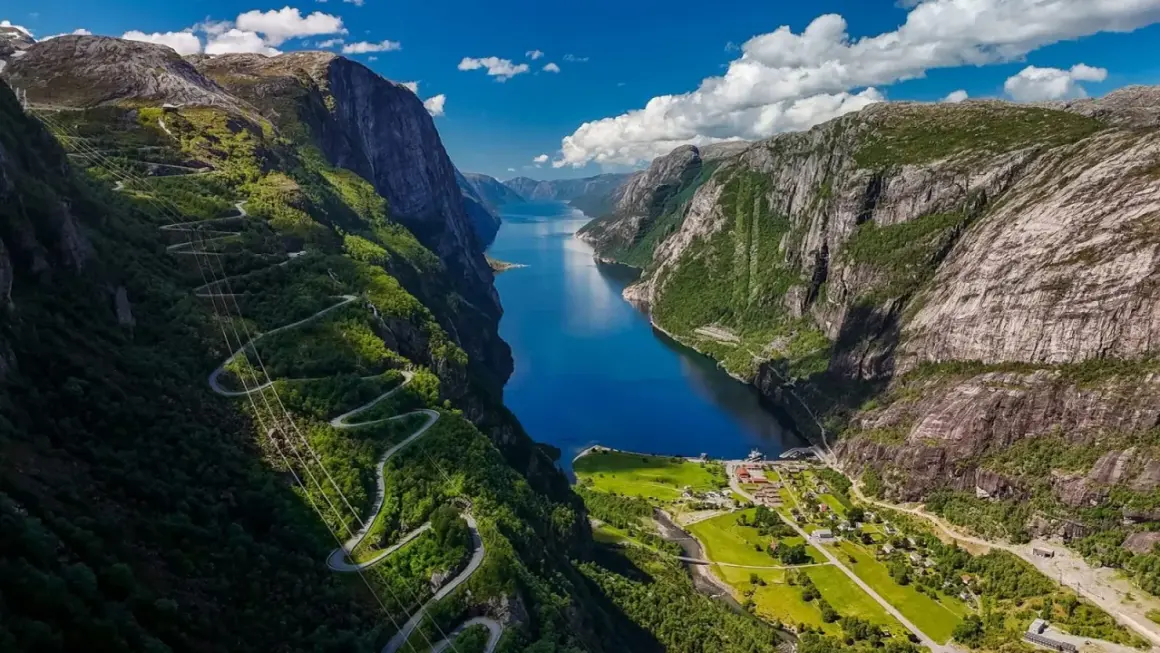 Malowniczy fiord z krętą drogą w górach. Idealne miejsce, gdzie na wakacje w lipcu, by podziwiać zapierające dech w piersiach widoki.