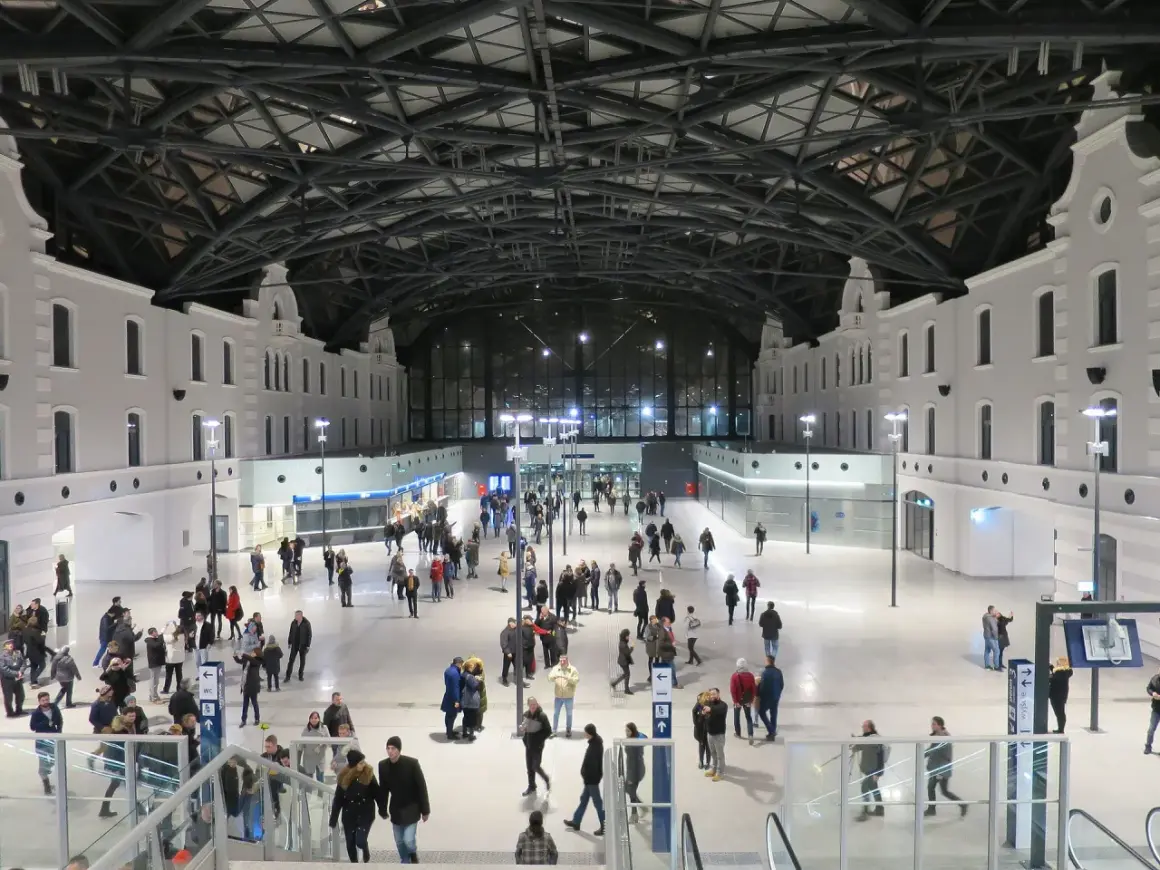 Nowoczesny dworzec Łódź Fabryczna, idealny punkt startowy, by zobaczyć co warto zobaczyć w Łodzi w jeden dzień. Tłumy podróżnych pod imponującym dachem.