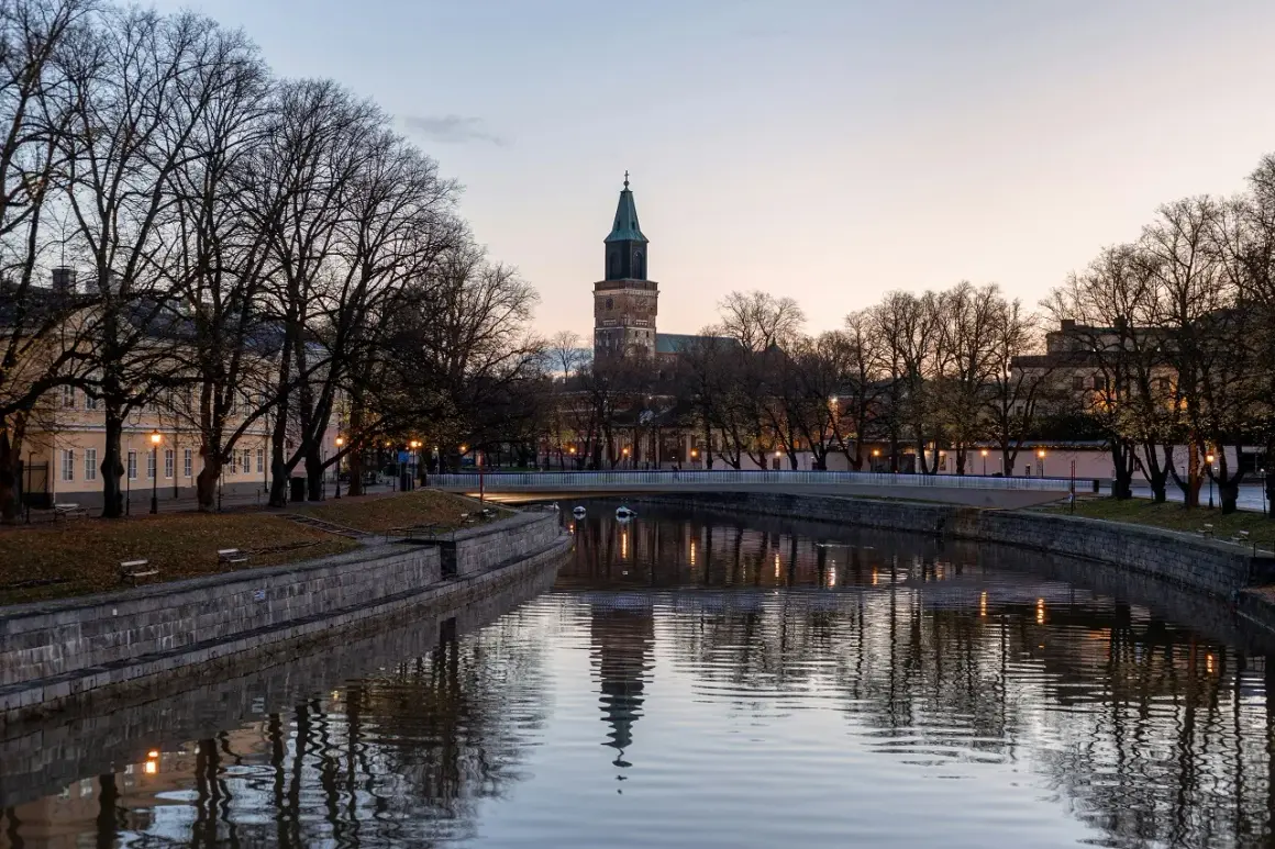 Wieczorny widok na rzekę w Turku, najstarszym mieście Finlandii, z katedrą w tle.