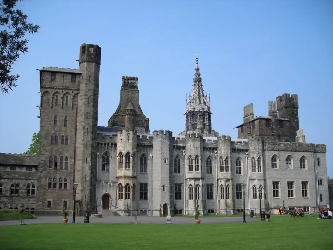 Zamek w Cardiff, stolicy Walii, z imponującą architekturą i zielonym trawnikiem.