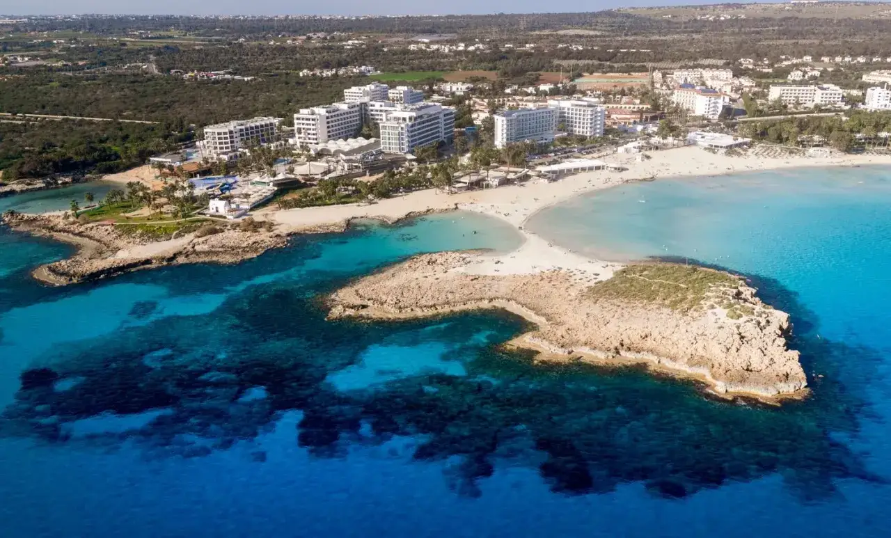 Widok z lotu ptaka na plaże i hotele w Ayia Napa. Turkusowe morze, piaszczyste plaże i skaliste wybrzeże to główne atrakcje tego miejsca.