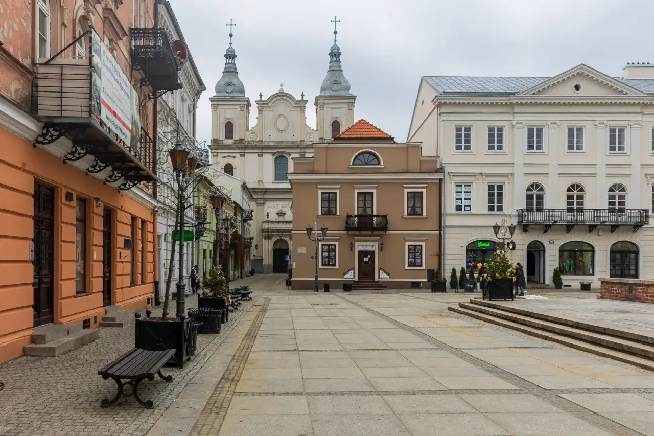 Piotrków Trybunalski atrakcje: Rynek z kamienicami, kościołem i choinką.